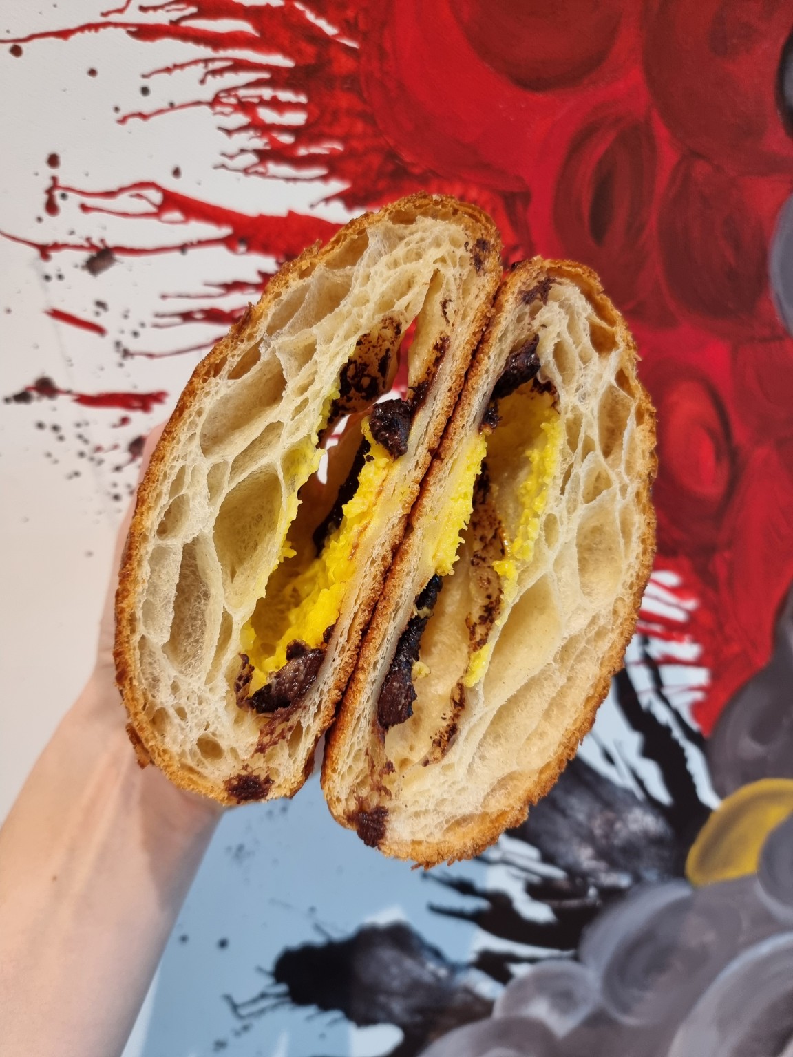 Una brioche farcita tagliata a metà, con la sfogliatura in evidenza