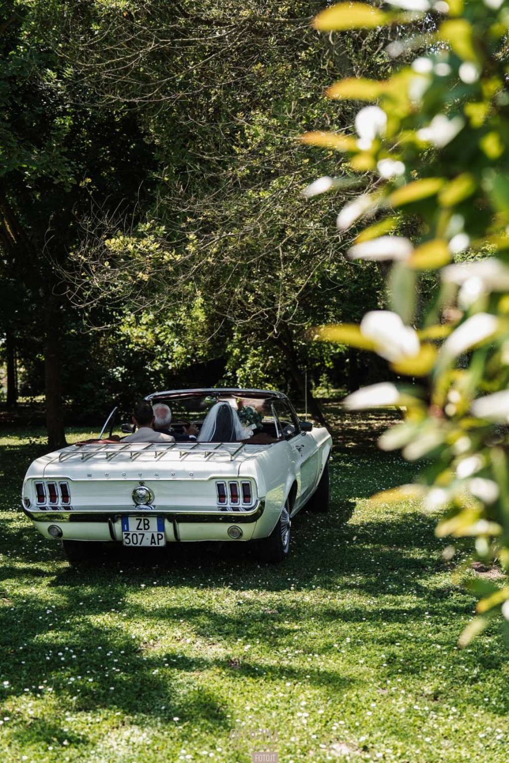 Gli sposi su un’auto d’epoca nel verde del giardino