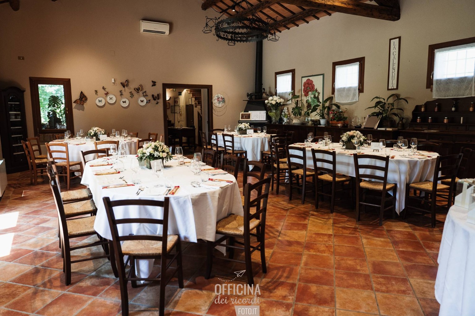 Sala rustica con travi in legno e tavoli apparecchiati